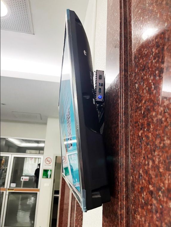 A screen mounted on a structural pillar in the library reading area, positioned beside wayfinding signs for Individual Study and Circulation Service.