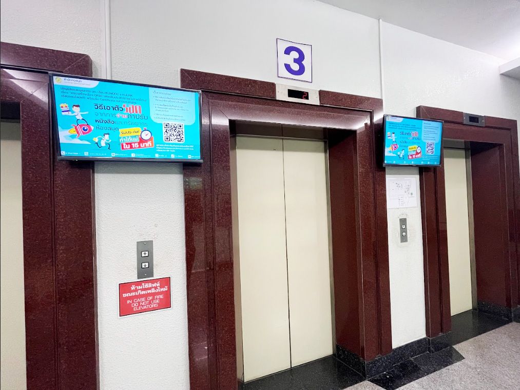 A close up view of the CAYIN SMP-2200 player mounted directly behind a digital signage display at Kasetsart University Library.